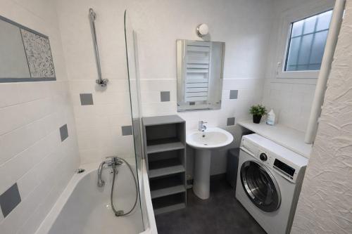 a bathroom with a washing machine and a sink at Maison paisible à Senlis in Senlis