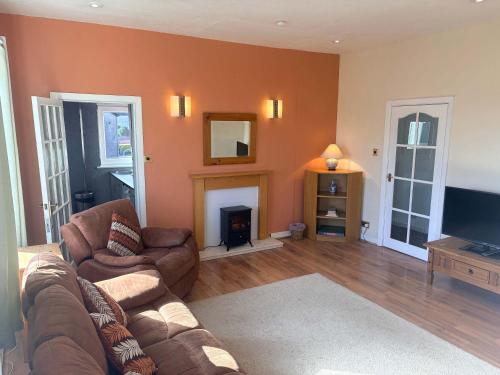 a living room with a couch and a fireplace at 3 Bed Cottage Flat with Parking in Glasgow