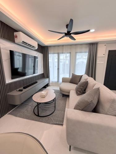 a living room with a couch and a flat screen tv at Marble Manor - Elegant Landed house in Subang Jaya