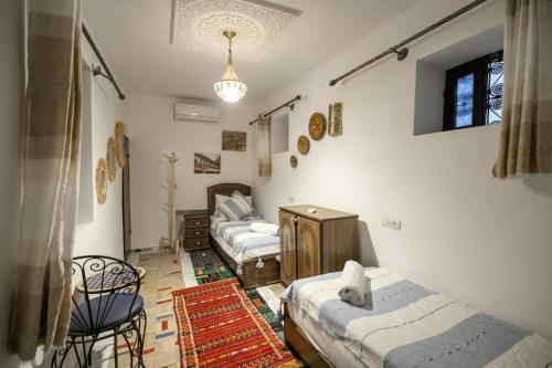 a room with four beds and a chandelier at Guest House Jnan Sbil in Fez