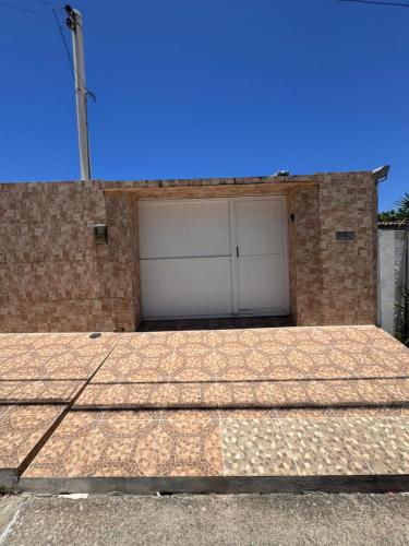 a garage with two white garage doors on a brick building at Casa Freire in Maceió