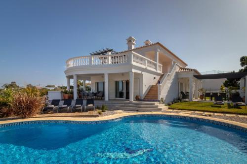 a villa with a swimming pool in front of a house at Villa Ocean Blue Ocean views Walk to beach Pool in Ferragudo