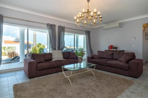a living room with two brown couches and a glass table at Villa Ocean Blue Ocean views Walk to beach Pool in Ferragudo