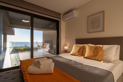 a bedroom with a large bed and a large window at Sun and Sea Apartment - Beachfront, 2 Bedrooms with Sea View & Garden in Paralio Astros