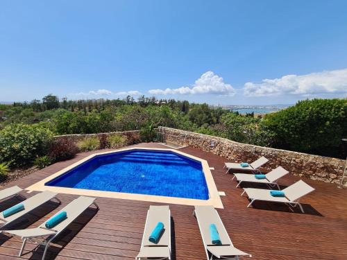 a swimming pool with chaise lounge chairs and a swimming pool at Villa Atlantic Blue Luxury with Ocean views in Ferragudo