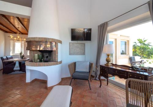 a living room with a fireplace and a desk at Villa Atlantic Blue Luxury with Ocean views in Ferragudo