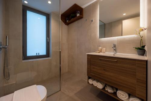 a bathroom with a sink and a shower with a window at Sun and Sea Apartment - Beachfront, 2 Bedrooms with Sea View & Garden in Paralio Astros