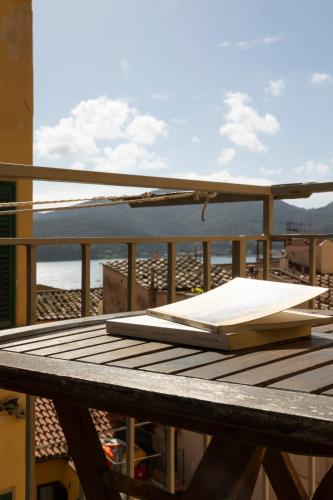 a notebook sitting on top of a table on a balcony at Tra Tetti e Mare - HelloElba in Portoferraio
