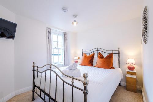 a bedroom with a bed with orange pillows at Cosy Lake District Cottage - Walk to Windermere - Sleeps 6 in Windermere