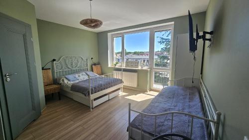 a bedroom with two beds and a large window at W Ustce Lipa in Ustka
