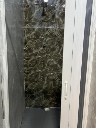 a bathroom with a shower with a stone wall at Pousada É de casa unidade 02 apto 01 in Juazeiro do Norte