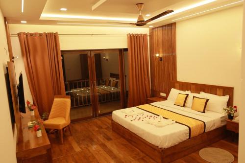 a hotel room with a bed and a balcony at Crystal Falls Wayanad in Wayanad