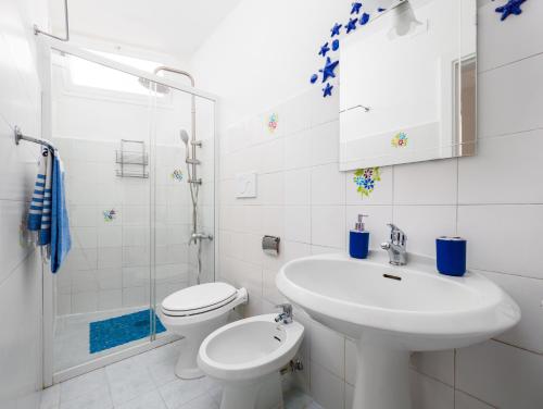 a white bathroom with a sink and a toilet at A la casa del cavaliere in Positano