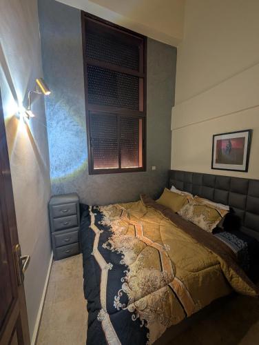 a bedroom with a bed and a window at Gueliz Appartement in Marrakesh