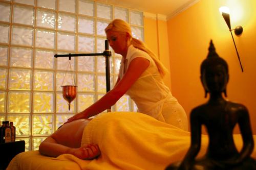 a woman in a dress cutting a womans hair at Berger's Sporthotel in Saalbach Hinterglemm