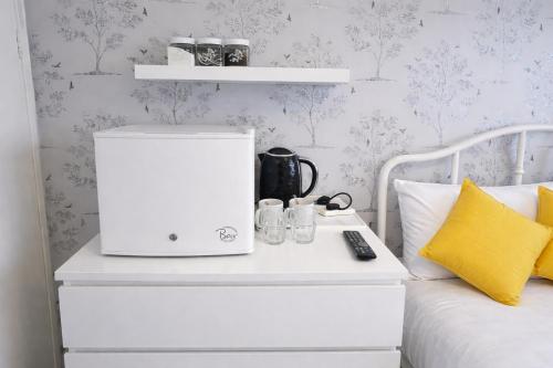 a bedroom with a bed with a white bedside table at The Roslyn Guest House in Paignton
