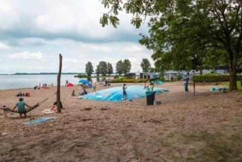 a group of people on a beach with a pool at Veluwemeer Retreat in Hulshorst