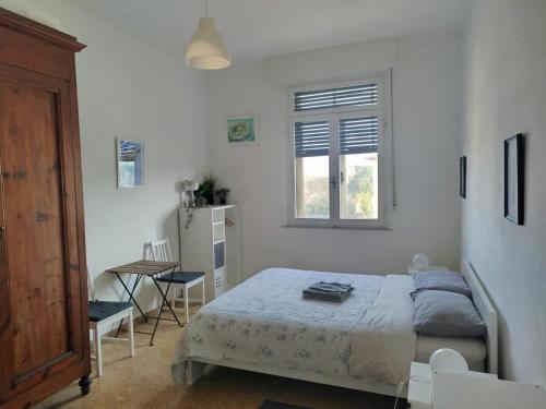 a bedroom with a bed and a table and a window at Treehouse - Spacious Private Rooms in Central Pisa Near Station & Airport in Pisa
