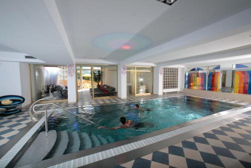 een groot zwembad met twee mensen zwemmen in het bij Berger's Sporthotel in Saalbach Hinterglemm