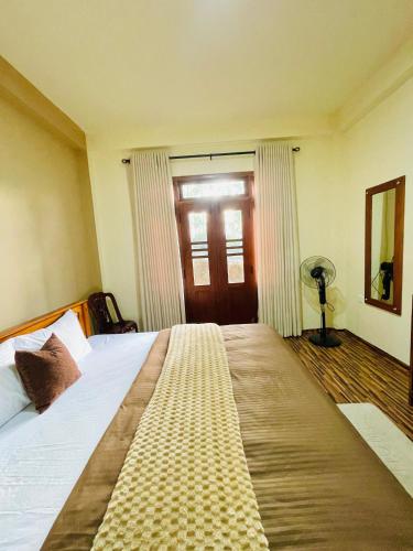 a bedroom with a large bed and a door at Yemi Bungalow Ella in Ella