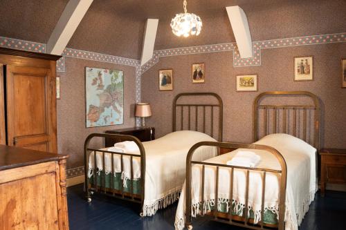 a bedroom with two beds and a chandelier at La Maison Coloniale - 15 Personnes - Piscine in Artagnan