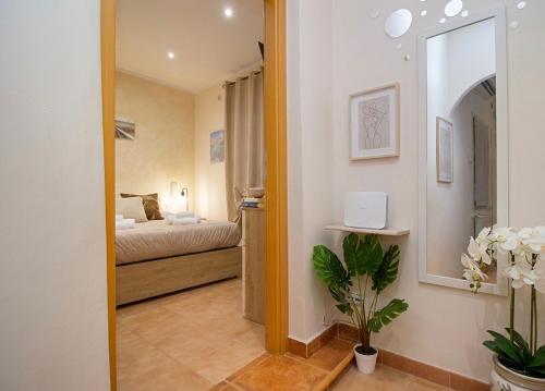 a hallway to a bedroom with a bed and a mirror at Raggio di Sole Suite in Valmontone