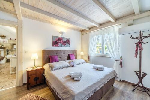 a bedroom with a large bed with purple pillows at Beachfront House Mir Brač near Supetar with pool and jacuzzi in Mirce