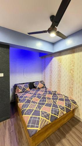 a bedroom with a bed with a blue wall at 7 Star Hotel in Surat