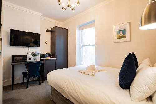a bedroom with a bed with a desk and a television at Superb Seafront Studio in Dublin