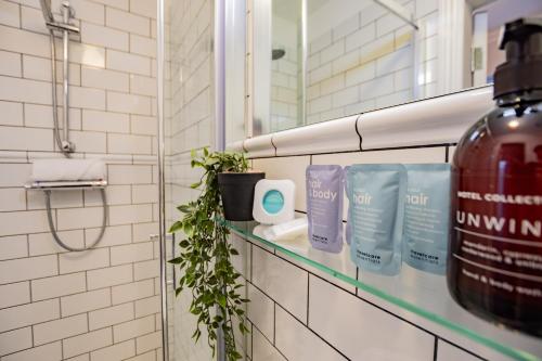 a bathroom with a shelf with a bottle of hair products at Superb Seafront Studio in Dublin
