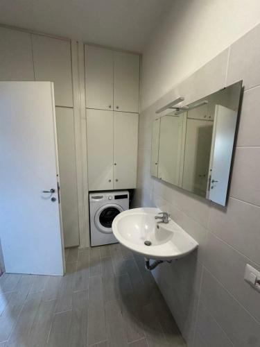 a bathroom with a sink and a washing machine at Sospesi nel borgo in Vitorchiano