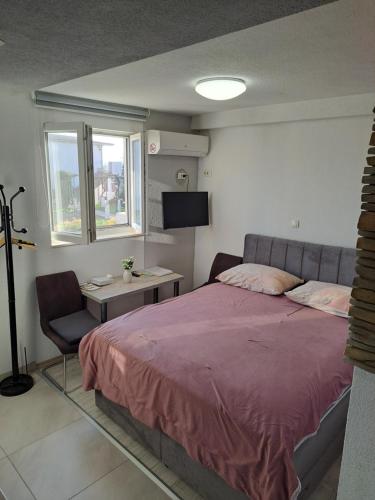 a bedroom with a bed and a chair and a television at Stone Guest House in Split