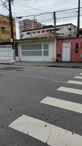 an empty street with a building and a crosswalk at Casa Amarelinha da Tupi in Praia Grande