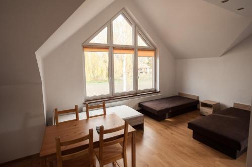 a room with a table and a bed and a window at Apartamenty Biskupice in Biskupice