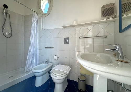 a bathroom with a sink and a toilet and a tub at Solemar Sicilia - Palazzo Eos e Aura in Porticello