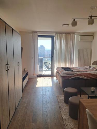 a bedroom with a bed and a window with a view at Tea Planet 2 in Niš