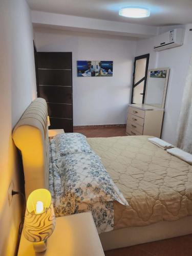 a bedroom with a bed and a dresser and a table at Apartment 3 by Villa Ceni in Elbasan