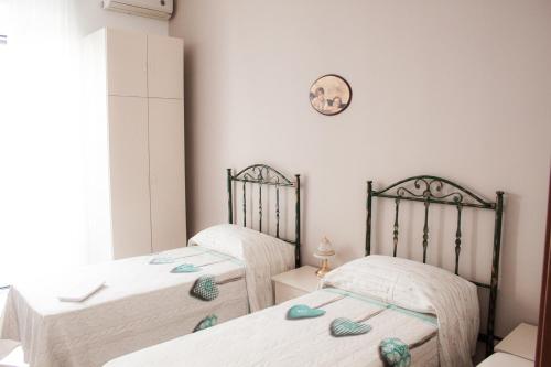 2 camas individuais num quarto com paredes brancas em A Casa di Amici em Toritto