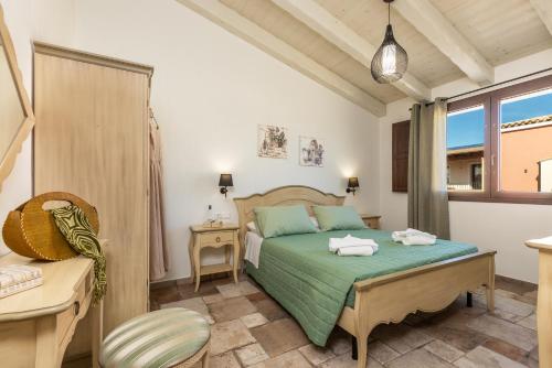 a bedroom with a bed and a chair and a window at Agorà Apartments in Villasimius