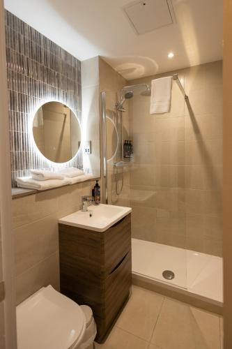 a bathroom with a toilet and a sink and a shower at Twin Trees Hotel & Brusna Falls Leisure in Ballina