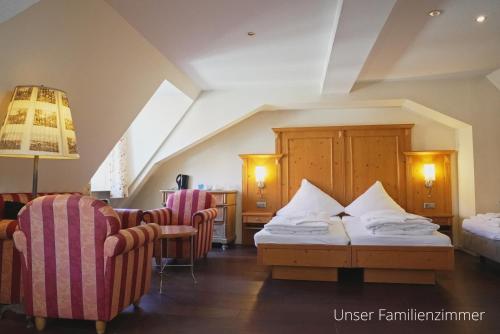 a hotel room with two beds and two chairs at Das Lamm Heidelberg in Heidelberg
