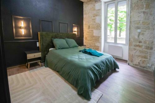 a bedroom with a green bed with a window at Charmant appartement - L'émeraude in Fontenay-le-Comte