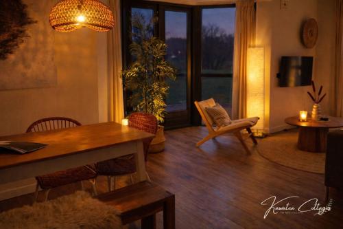 a living room with a table and chairs and a window at Lakeview 'Rotorua' 4-6 pers by Kawatea Cottages in Ewijk