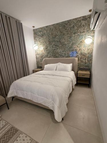 a bedroom with a large bed and a wall at نزل عطيف - وصول ذاتي in Al Kharābah