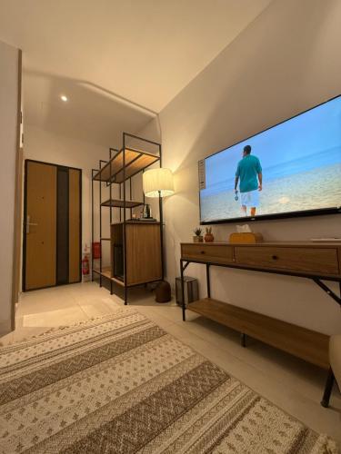 a living room with a large screen tv at نزل عطيف - وصول ذاتي in Al Kharābah