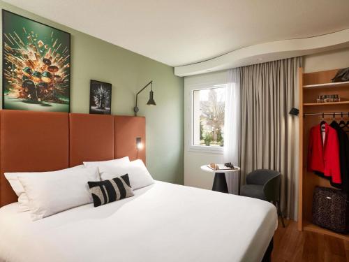 una camera d'albergo con un letto e una finestra di ibis Caen Centre a Caen