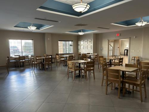 a dining room with wooden tables and chairs at Country Inn & Suites by Radisson, Oklahoma City - Quail Springs, OK in Oklahoma City