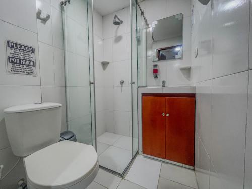 a bathroom with a toilet and a glass shower at Hostal Kumbaya in Santa Marta
