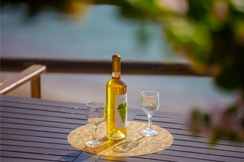 a bottle of wine and two wine glasses on a table at Panorama Beach in Chrani