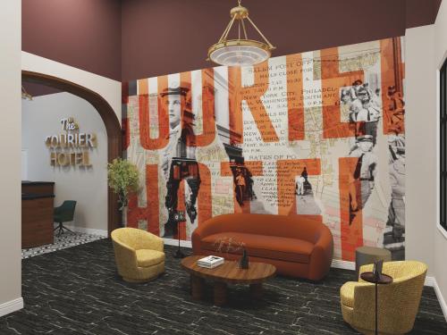 a lobby with a couch and chairs and a wall at The Courier Hotel in Salem